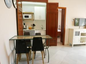 a kitchen and dining room with a table and chairs at Sierpes 50 in Seville