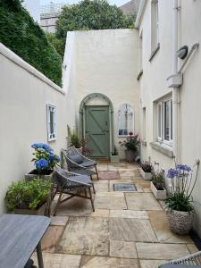 um pátio com uma porta verde e cadeiras em frente a um edifício em Luxury house with Sea views em Bangor