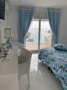 um quarto com uma cama e vista para o oceano em Hotel La Calanque em Cavalaire-sur-Mer