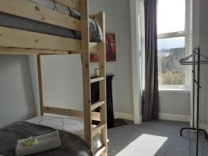 a bedroom with a bunk bed and a window at Castleview is a lovely flat in a listed building in Rothesay