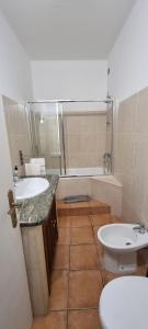 y baño con 2 lavabos, aseo y bañera. en Casa da Rua da Fonte en Ferreira do Alentejo