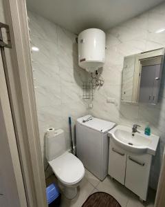 La salle de bains blanche est pourvue de toilettes et d'un lavabo. dans l'établissement Затишна Smart-Квартира, à Kiev