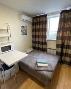 Cette petite chambre comprend un lit et un bureau. dans l'établissement Затишна Smart-Квартира, à Kiev