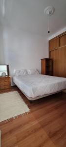 1 dormitorio con 1 cama y armario de madera en Casa da Rua da Fonte en Ferreira do Alentejo