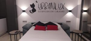 a bedroom with a bed with red and black pillows at Urbanlux Olimpia Pet Friendly in Albacete