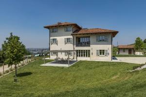 ein großes weißes Haus mit einem großen Hof in der Unterkunft Santa Caterina Langhe in La Morra