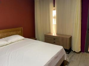 1 dormitorio con cama blanca y ventana en City Apartments en Port Louis