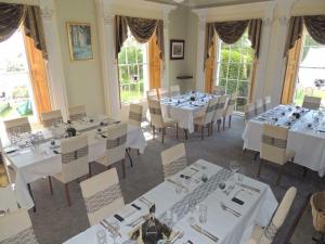 een eetkamer met witte tafels en stoelen bij St Nicholas House in Spalding