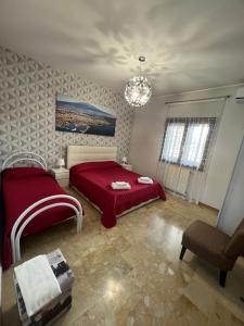 a bedroom with a red bed and a chandelier at Casa Vacanze Volpe Dell'Etna in Nicolosi