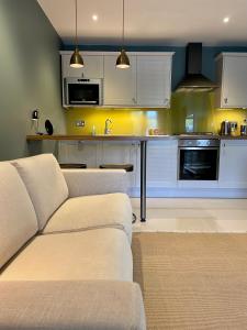 a living room with a couch and a kitchen at The Apartments @ Quidhampton Mill in Salisbury