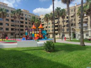 un parque infantil frente a un gran edificio en Biopark View Apartment, en Valencia