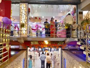a group of people walking through a shopping mall at Hotel G M FORUM in Kānpur