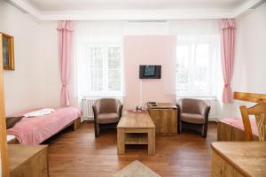 um quarto com duas camas e uma mesa e cadeiras em Hotel Džbán em Karlova Studánka
