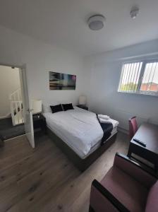 a bedroom with a bed and a couch and a chair at City Apartments Charles Street in Hull