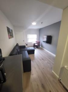 a living room with a couch and a tv at City Apartments Charles Street in Hull
