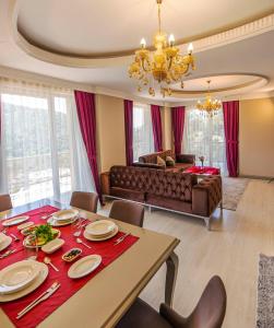 een woonkamer met een tafel en een bank bij Sarot Thermal Palace Tatil Köyü - Halal Hotel in Karacasumandıra