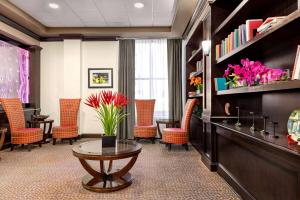 - une salle d'attente avec une table, des chaises et des fleurs dans l'établissement IBAN Hotel, Trademark Collection by Wyndham, à Dallas