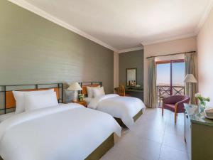 2 Betten in einem Hotelzimmer mit Aussicht in der Unterkunft Grand Mercure Petra in Wadi Musa