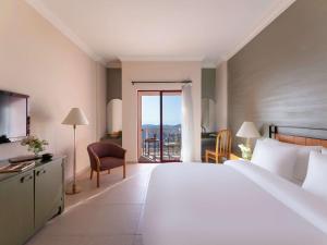 ein Hotelzimmer mit einem großen Bett und einem Balkon in der Unterkunft Grand Mercure Petra in Wadi Musa