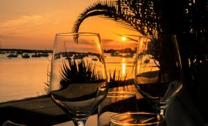 two wine glasses sitting on a table near the water at Hostal la Savina in La Savina