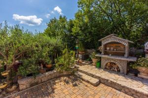 a garden with a stone patio with a fireplace at Apartments RUZA in Crikvenica