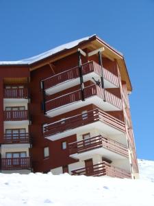 un edificio con balcones en la nieve en Necou 721 en Les Menuires