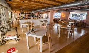 a restaurant with tables and chairs in a room at Hostal la Savina in La Savina