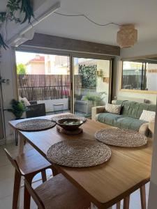 a living room with a wooden table with four plates on it at Centre de Juan les pins 100m plages Easy Check-in in Juan-les-Pins