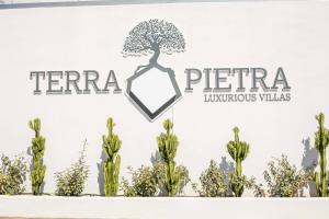 a sign for theeriaeria hyundai villas with trees at Terra Pietra Luxury Villas & Suites in Lartos