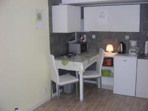 a kitchen with a table and chairs in a kitchen at Kleine FEWO zentral gelegen in Künzell