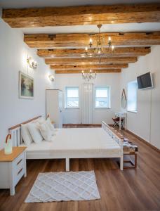 a bedroom with a large white bed and wooden ceilings at Fernweh Haus Brasov in Braşov