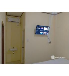 a bathroom with a tv on the wall of a room at Navisha Guest House Syariah near Exit Tol Batang RedPartner in Pekalongan