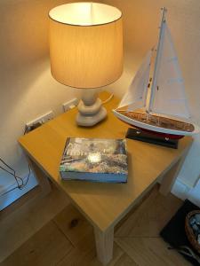 a table with a toy sailboat on it with a lamp at Cedar Cottage in Warrenpoint