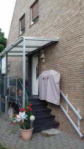 ein Haus mit einer Veranda mit weißem Hemd an der Tür in der Unterkunft Doms-Baumhammer, Auf dem Baer 4 in Viersen
