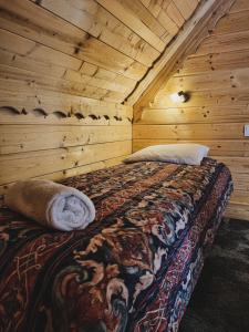 1 dormitorio con 1 cama en una cabaña de madera en Domek Na Wypasie, en Jugów