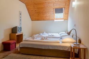 1 dormitorio con 1 cama con techo de madera en Sylvia Ház, en Tihany
