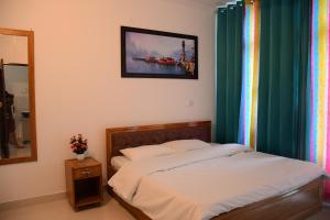 ein Schlafzimmer mit einem Bett und einem Bild an der Wand in der Unterkunft River Stay - Homestay by Wanderlust Rural Tourism in Dehradun