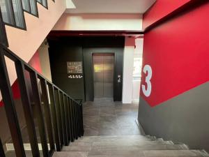 a hallway of a building with a red wall and a door at Penpark Place in Bangkok