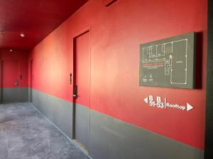 a room with a red wall with a sign on it at Penpark Place in Bangkok