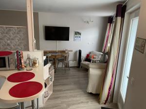 een kamer met een keuken met een tafel en een televisie bij Studio rez-de-chaussée, à Lesquin/Lille aéroport in Lesquin