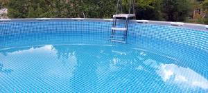 une piscine bleue avec une échelle dans l'eau dans l'établissement Ferienwohnung Hans, à Lindenfels