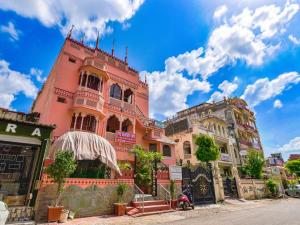 a tall pink building on a city street at The Maurvi Inn in Jaipur
