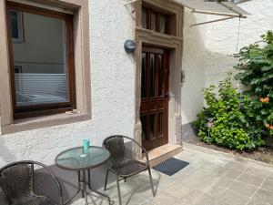 a patio with a table and chairs in front of a door at Ferienwohnung Stiegel in Ingelheim am Rhein