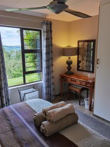 Bergview的住宿－Misty peaks Cloudlands，一间卧室配有一张带镜子的床和一张书桌