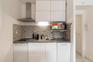 a kitchen with white cabinets and a sink at Appartement 2 pièces au calme proche Martinez avec parking privé in Cannes