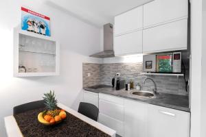 a kitchen with a table with a bowl of fruit on it at Appartement 2 pièces au calme proche Martinez avec parking privé in Cannes