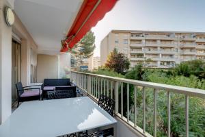 a balcony with a table and chairs and a building at Appartement 2 pièces au calme proche Martinez avec parking privé in Cannes