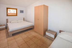a small bedroom with two beds and a cabinet at House Agava Rei in Tkon