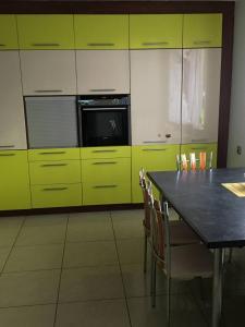 kuchnia z żółtymi szafkami i stołem z krzesłami w obiekcie Willa Mateusza w mieście Sandomierz