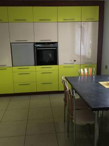 a kitchen with yellow cabinets and a table with chairs at Willa Mateusza in Sandomierz +5 photos